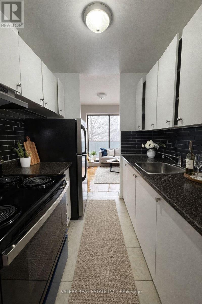 A modern kitchen with black appliances and white cabinets.