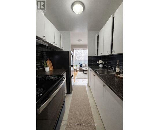 A modern kitchen with black appliances and white cabinets.