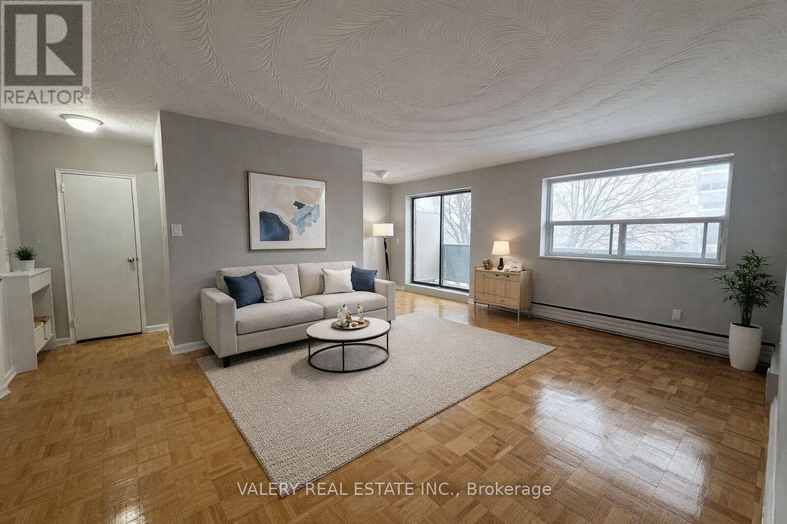A living room with a couch, a coffee table, and a painting on the wall.