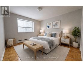 A bedroom with a bed, nightstands, and a plant.