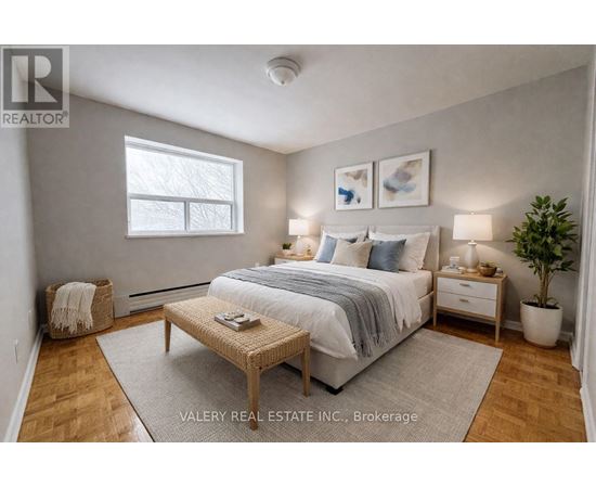 A bedroom with a bed, nightstands, and a plant.