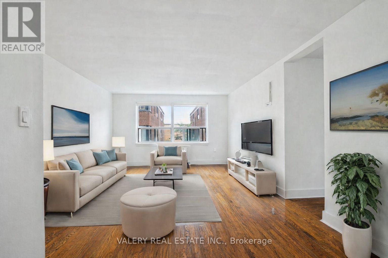 A living room with a couch, a chair, a coffee table, and a television.