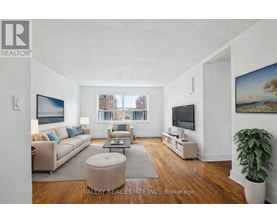 A living room with a couch, a chair, a coffee table, and a television.