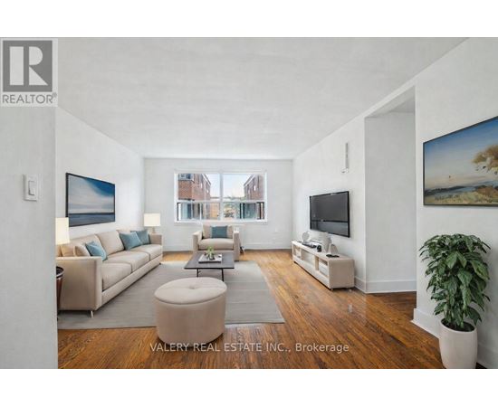 A living room with a couch, a chair, a coffee table, and a television.