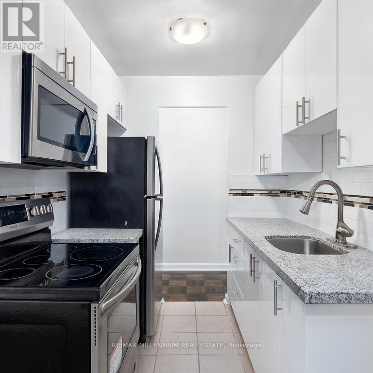 A kitchen with a black stove top oven and a black refrigerator.