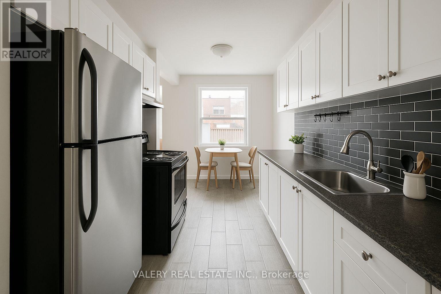 A kitchen with black and white appliances and cabinets.
