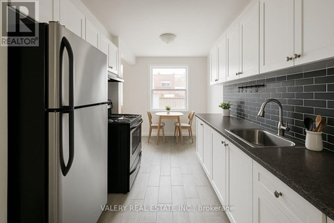 A kitchen with black and white appliances and cabinets.