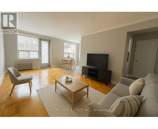 A living room with a couch, chair, and television.