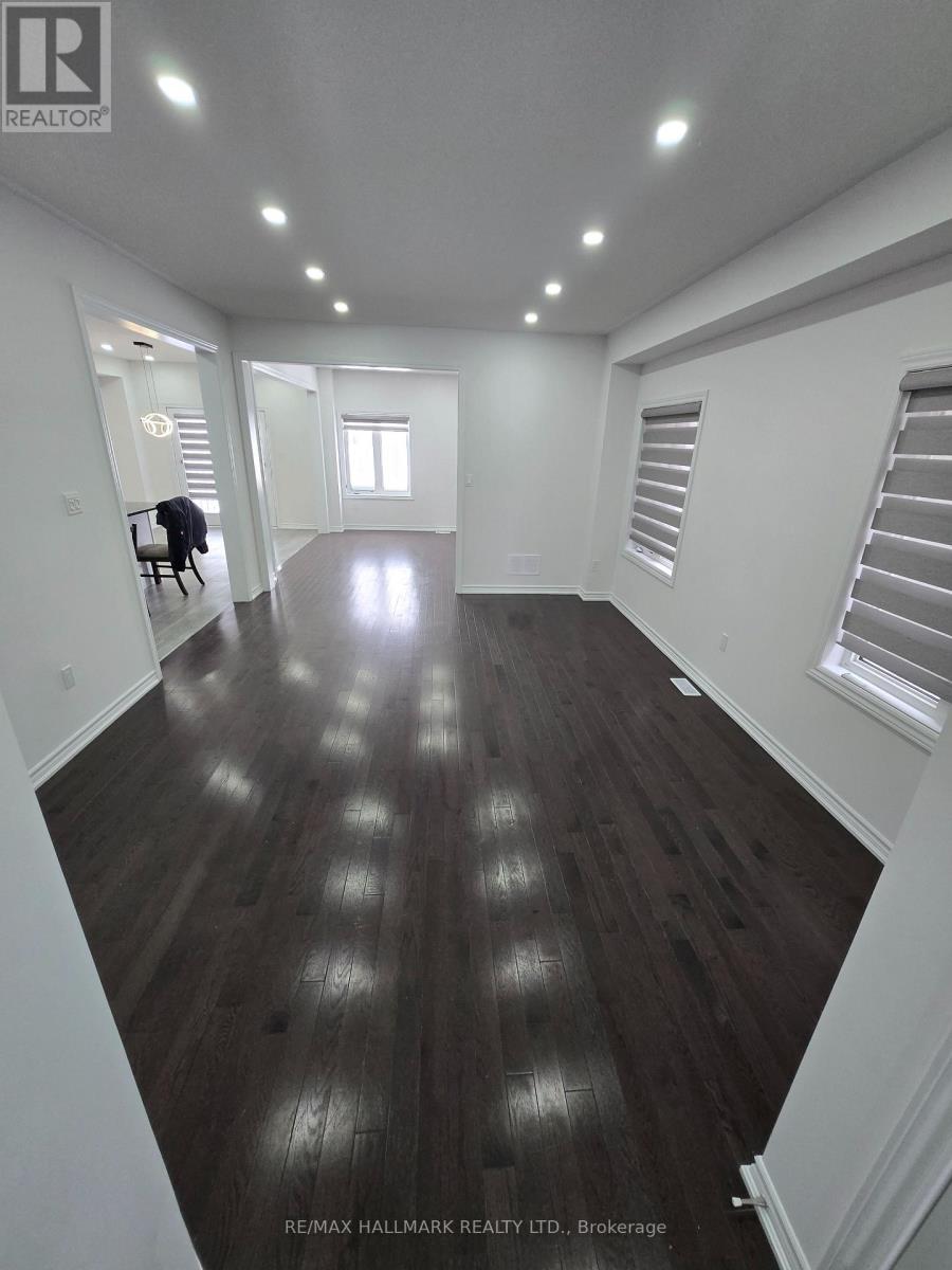 A spacious room with wooden flooring and white walls.