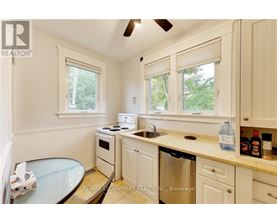 A kitchen with white cabinets and a glass table.