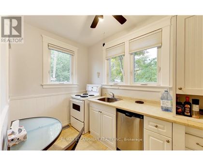 A kitchen with white cabinets and a glass table.