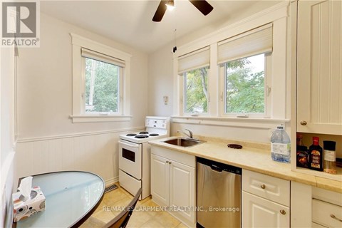 A kitchen with white cabinets and a glass table.