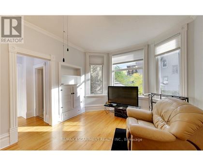 A living room with a leather sofa and a television.