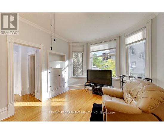 A living room with a leather sofa and a television.