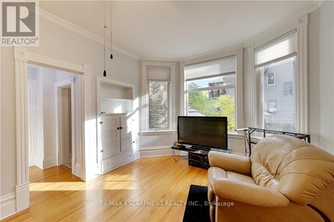 A living room with a leather sofa and a television.