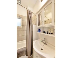A white bathroom with a white sink and a white bathtub.
