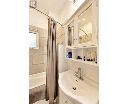 A white bathroom with a white sink and a white bathtub.