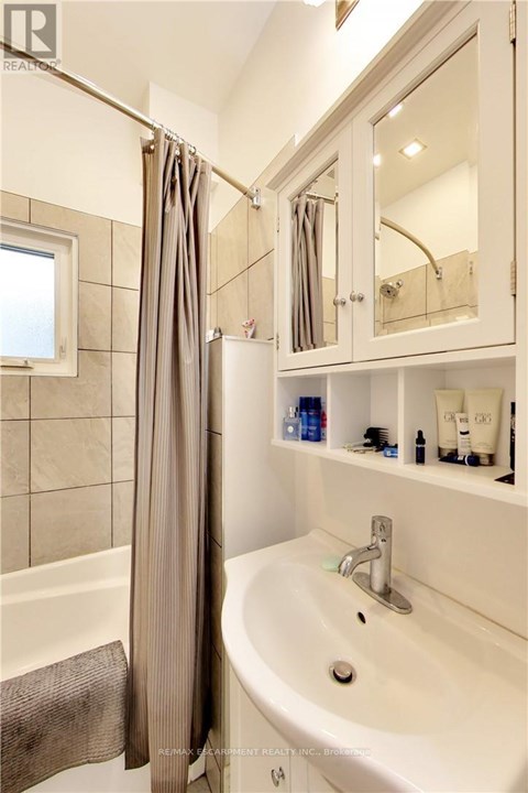 A white bathroom with a white sink and a white bathtub.