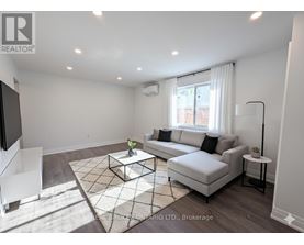 A living room with a white couch, a coffee table, and a television.