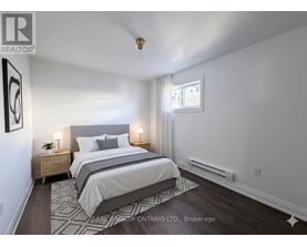 A bedroom with a large bed and two nightstands.