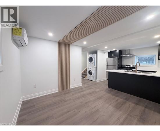 A modern kitchen with a washing machine and dryer built into the cabinetry.