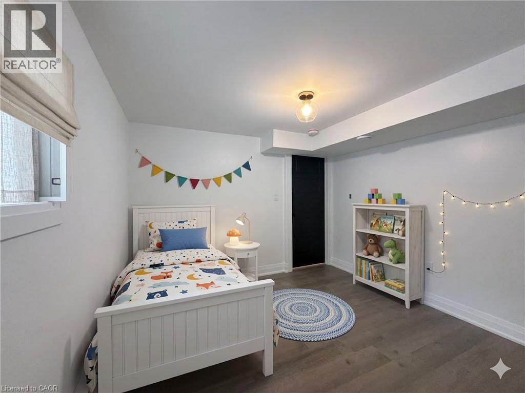 A bedroom with a white bed and a bookshelf with lights strung up.