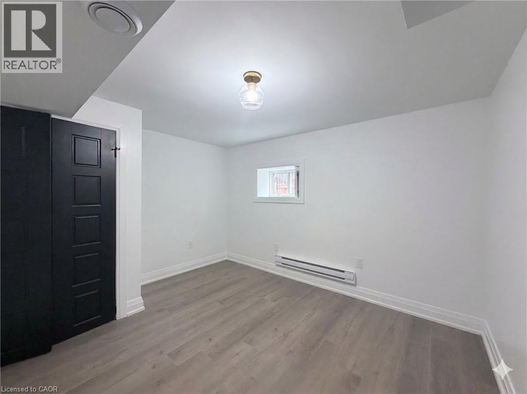 A room with a wooden floor and a black door.