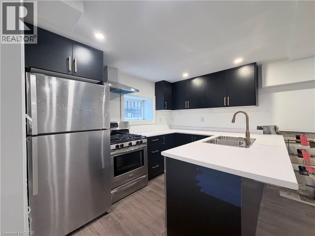 A modern kitchen with a stainless steel refrigerator and black cabinets.