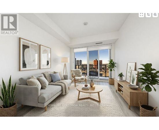 A well-lit living room with a grey sofa and a wooden coffee table.