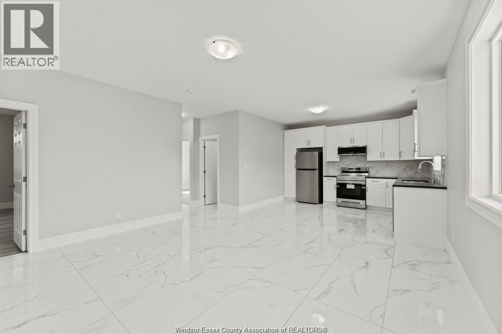 A spacious kitchen with white cabinets and appliances.
