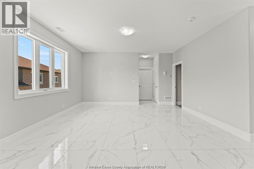 A spacious room with marble flooring and a large window.