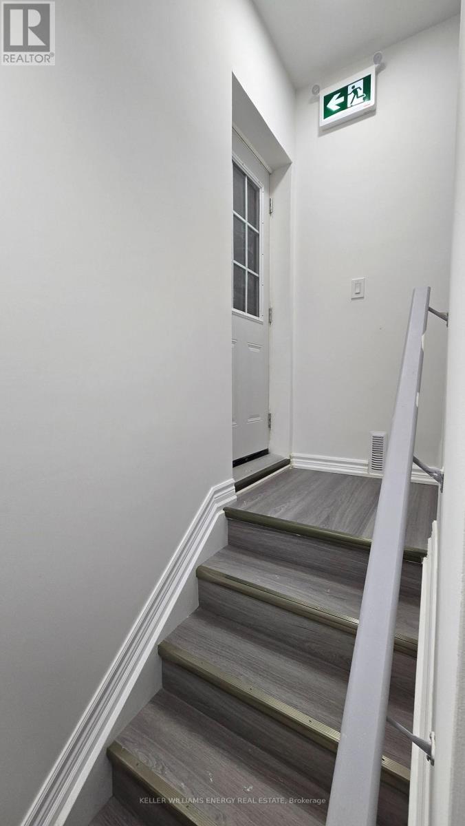 A stairway leading to a door with a green exit sign above it.