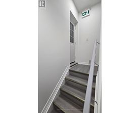 A stairway leading to a door with a green exit sign above it.