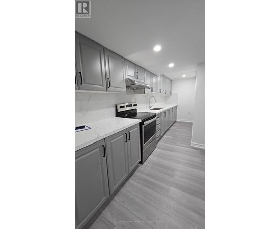 A kitchen with a white counter top and grey cabinets.