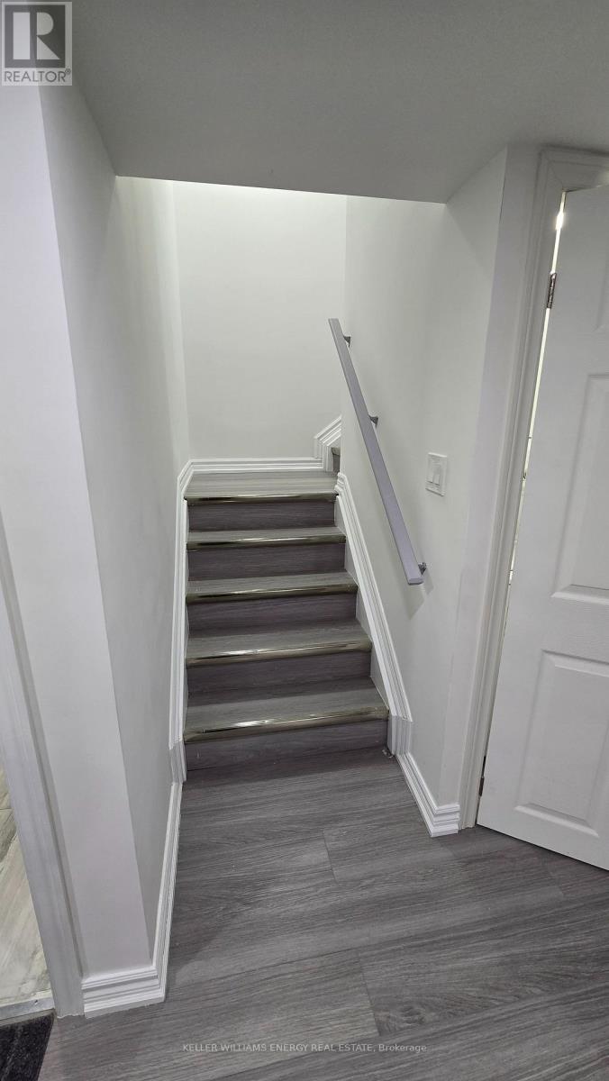A staircase with a grey carpeted floor and white walls.