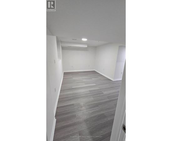 A spacious room with a grey floor and white walls.