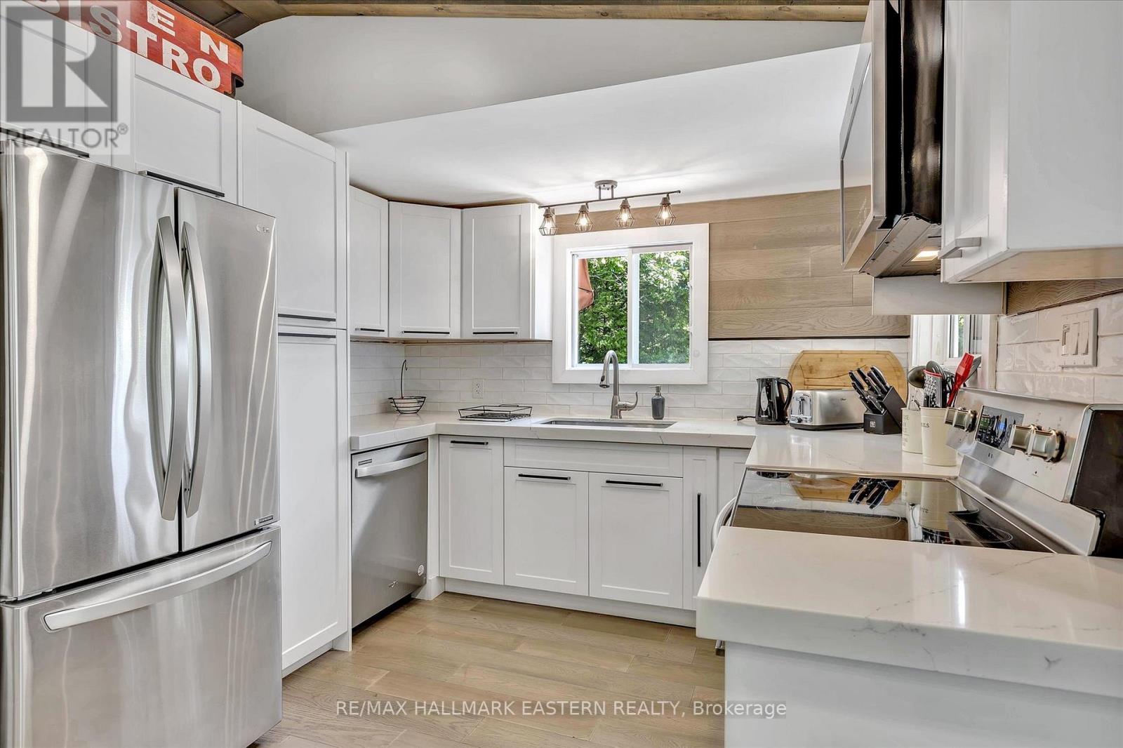 A kitchen with white cabinets and appliances.