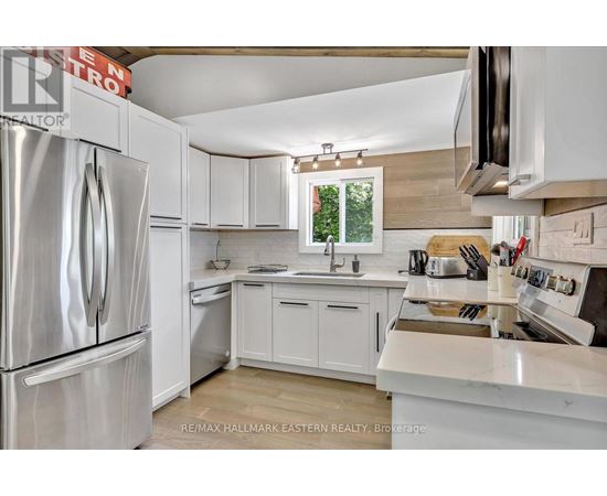 A kitchen with white cabinets and appliances.
