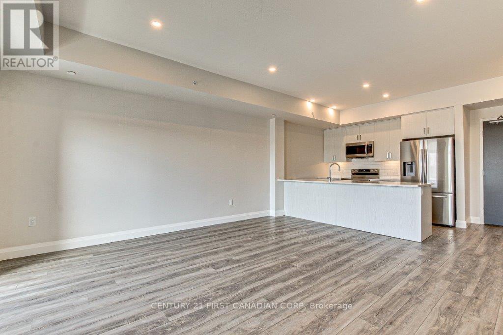 A spacious living room with a kitchen area in the background.