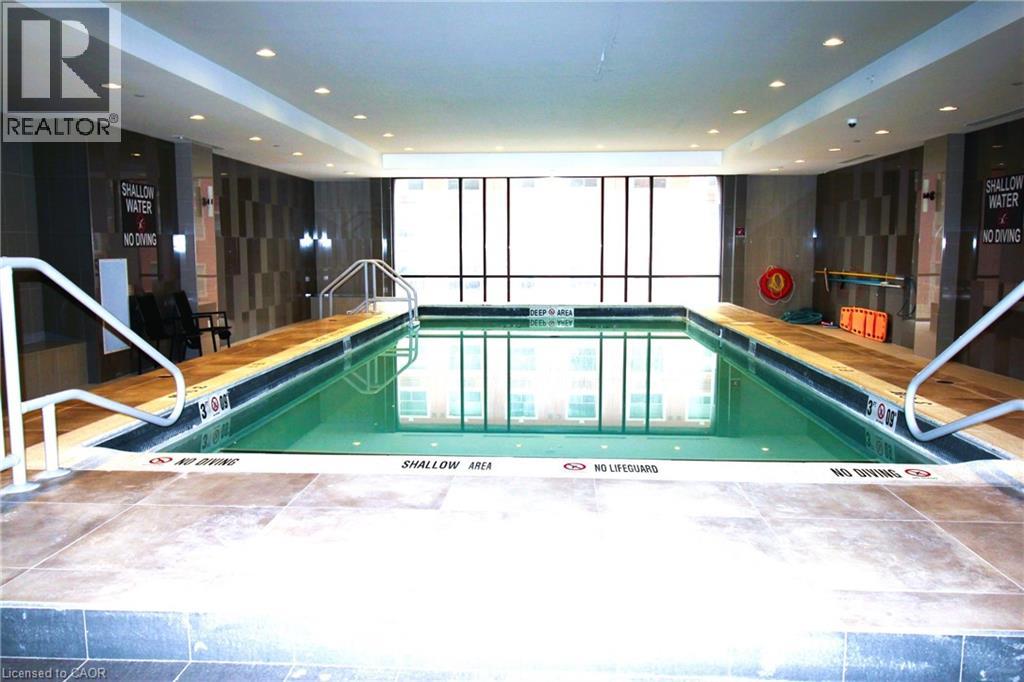 A large indoor swimming pool with a glass wall on one side.