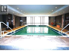 A large indoor swimming pool with a glass wall on one side.