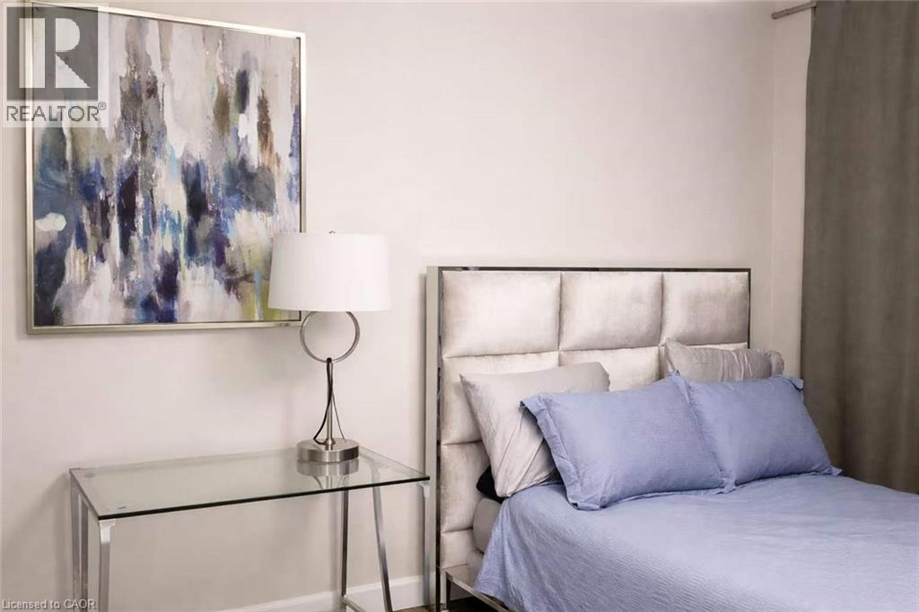 A bedroom with a bed, nightstand, and a painting on the wall.