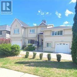 A large house with a white garage door is for sale.