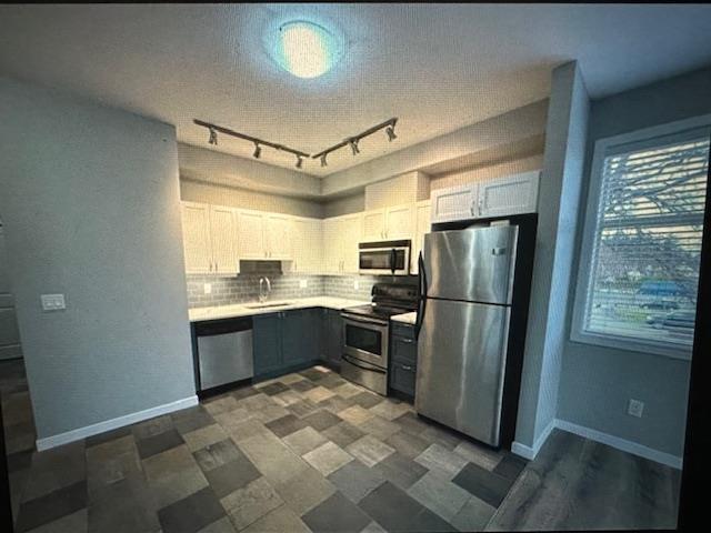 A kitchen with a checkered floor and stainless steel appliances.