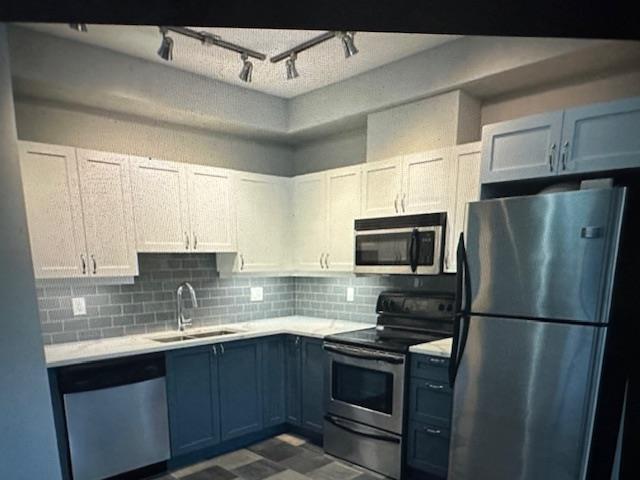 A kitchen with a stainless steel refrigerator, dishwasher, oven, and microwave.