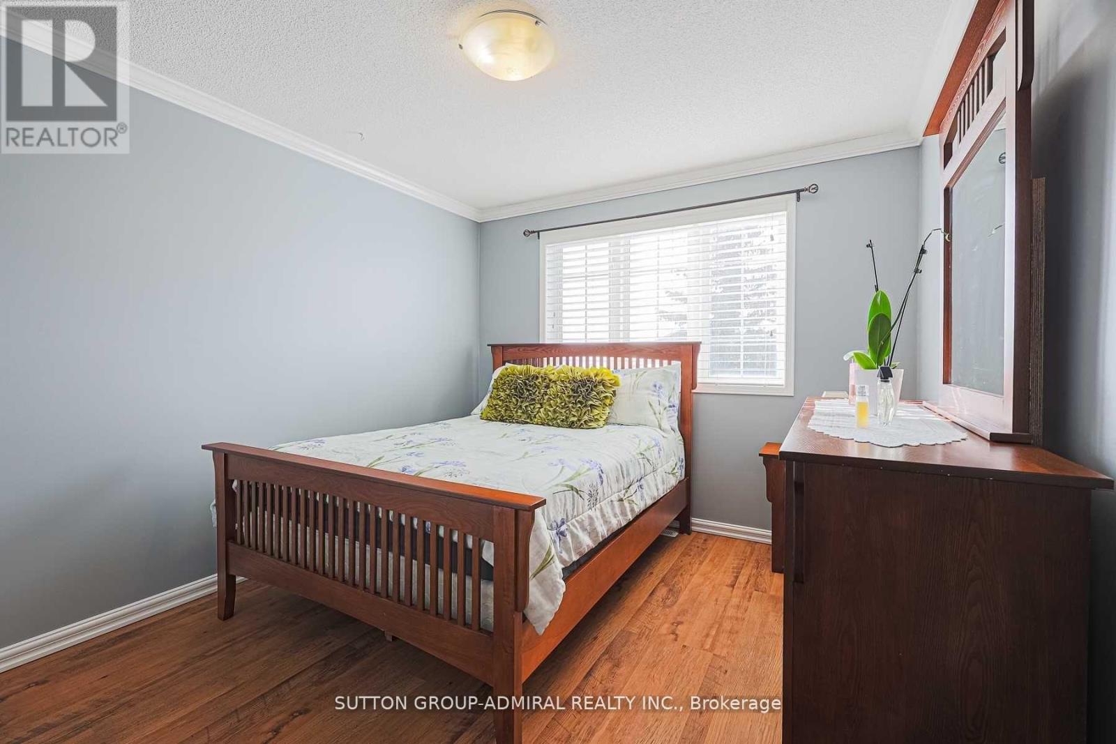 A bedroom with a bed, nightstand, and window.