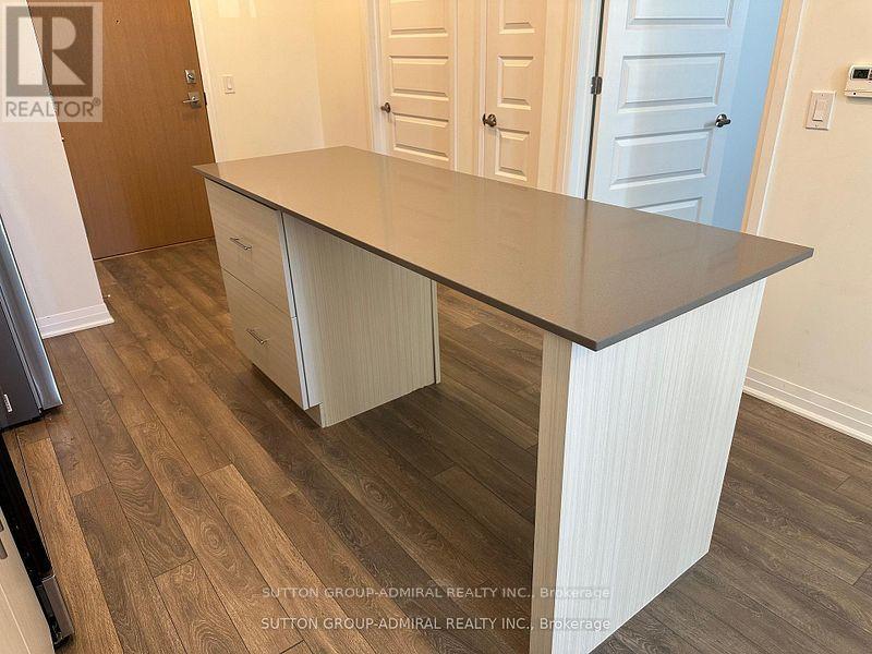 A kitchen island with a countertop and cabinets in a room with wood flooring.