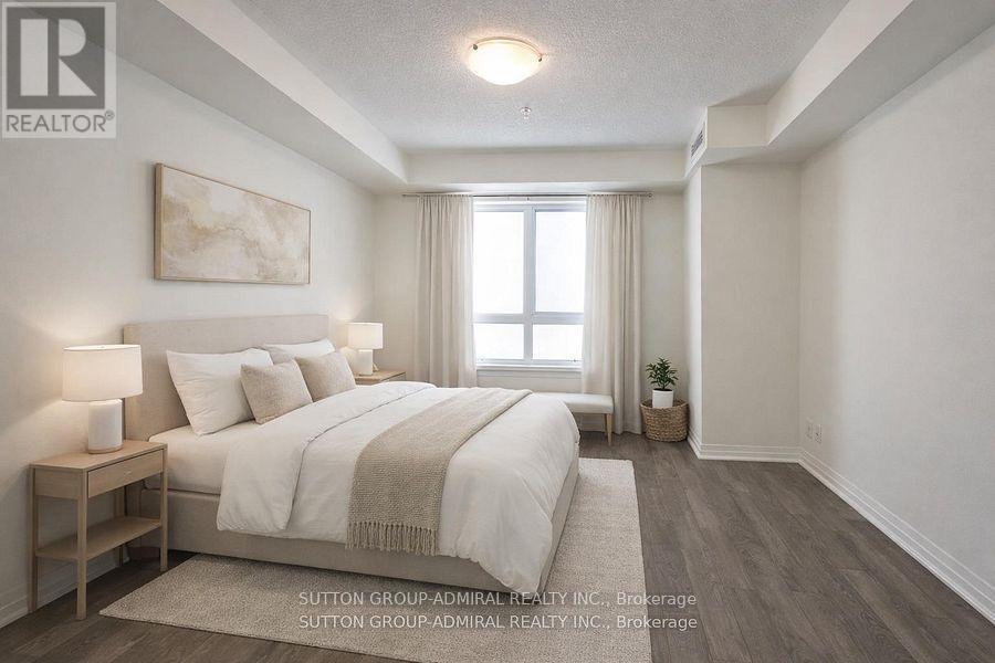 A bedroom with a large bed and a window with curtains.