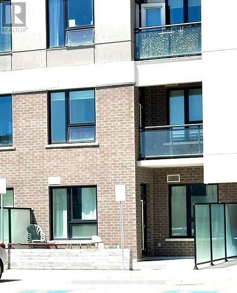 A building with a balcony and a pool in front.