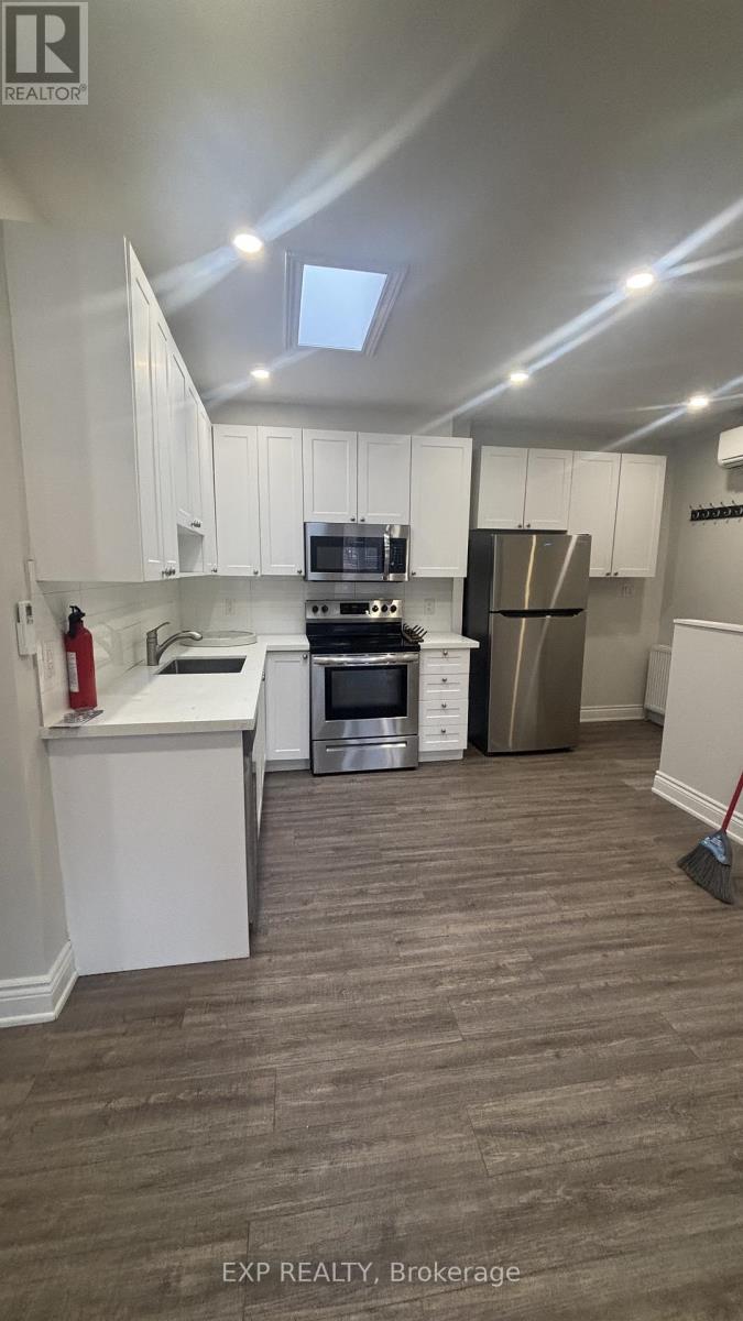 A kitchen with white cabinets and a stove top oven.
